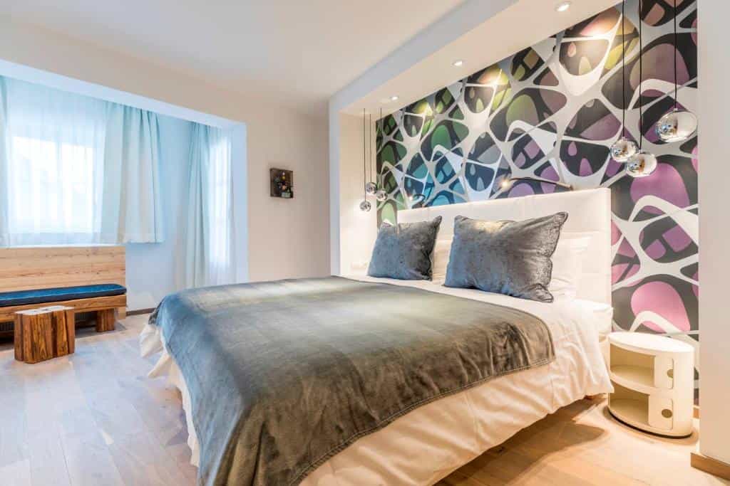 Hotel Flachauerhof room with modern abstract feature wall and wooden furniture.