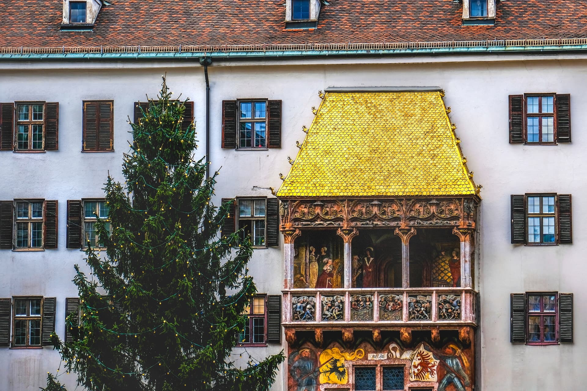 Christmas tree outside the Golden Roof building facade in Innsbruck during winter.