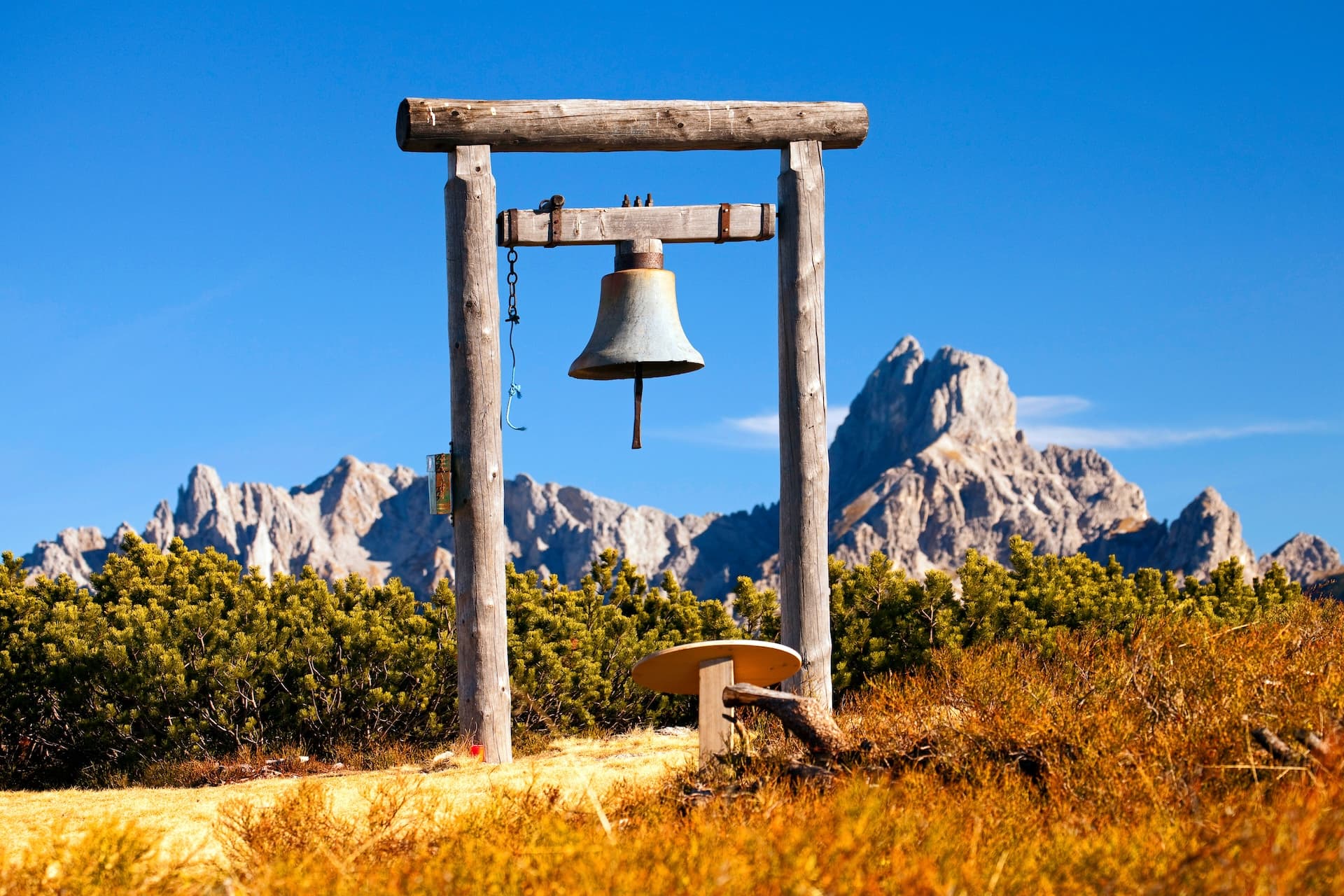 Wooden bell structure on hiking trail with rocky mountains in St. Martin im Tennengebirge.