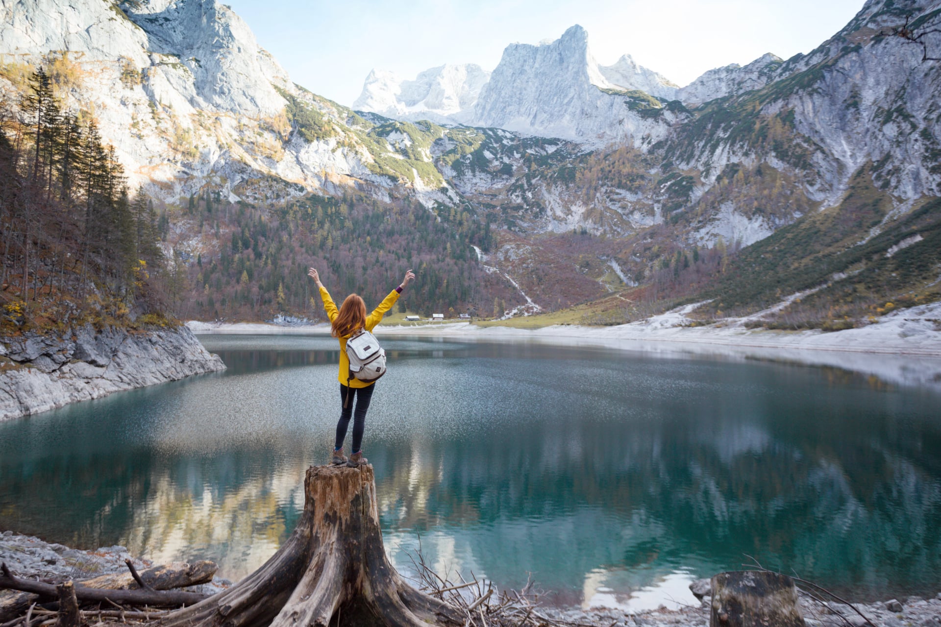 fille se tient sur le rivage d'un lac de montagne