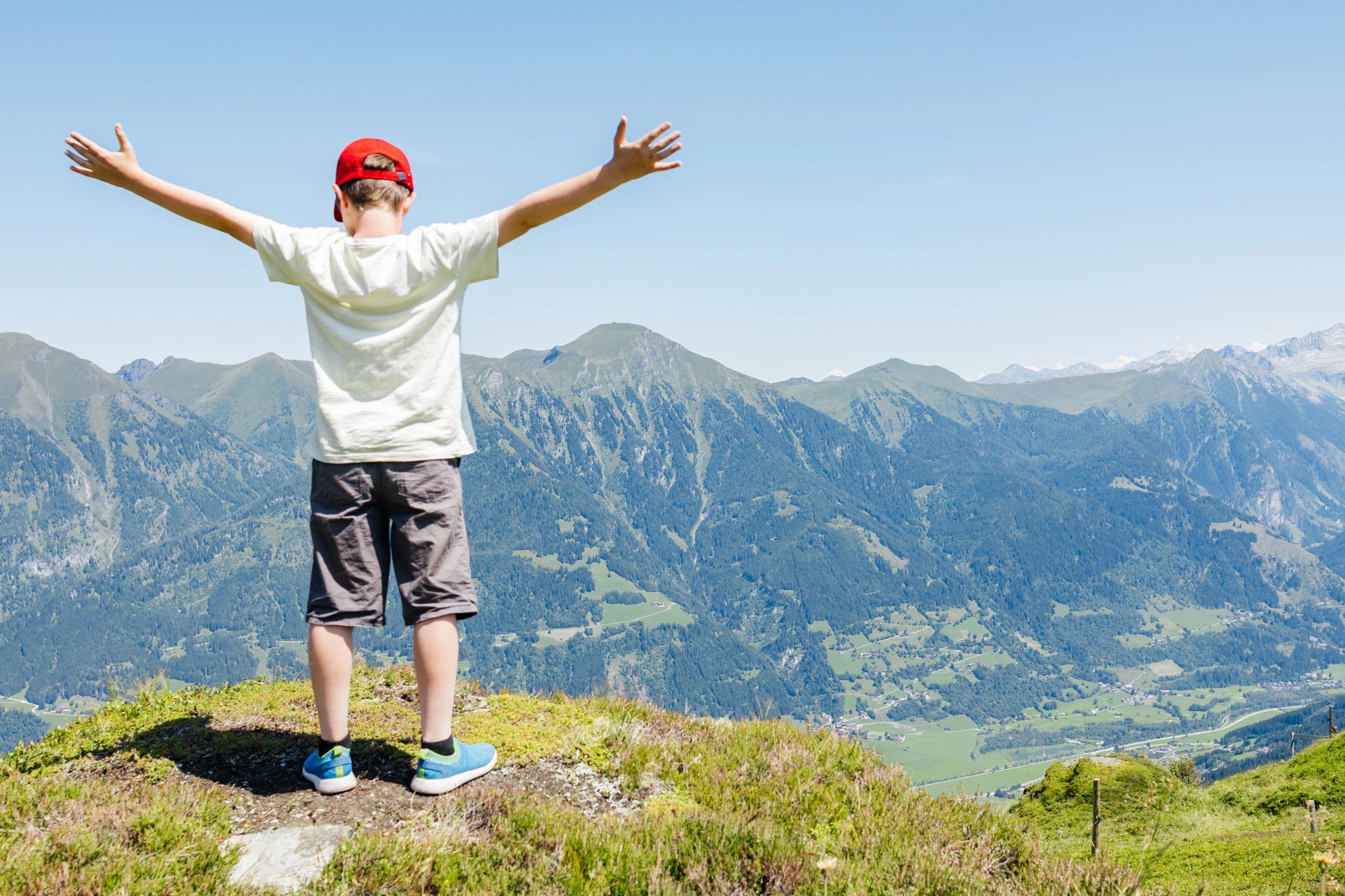 Jeune embrassant la vue de la montagne les bras ouverts