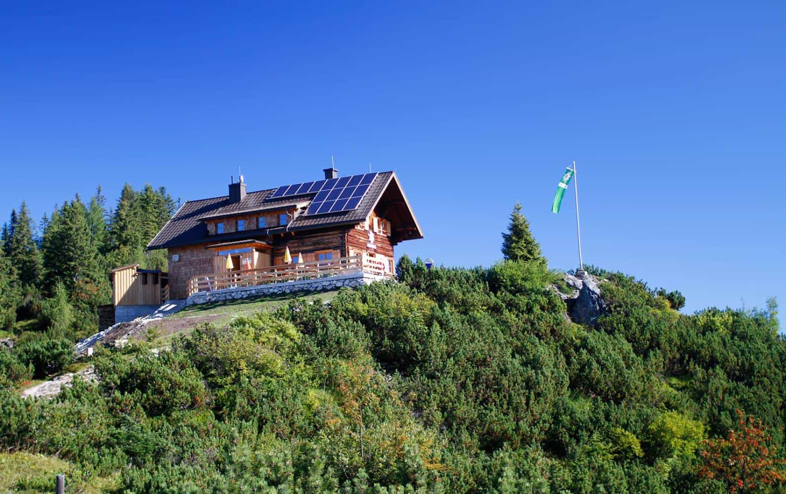 Goisererhütte wooden mountain hut with solar panels on a sunny alpine slope