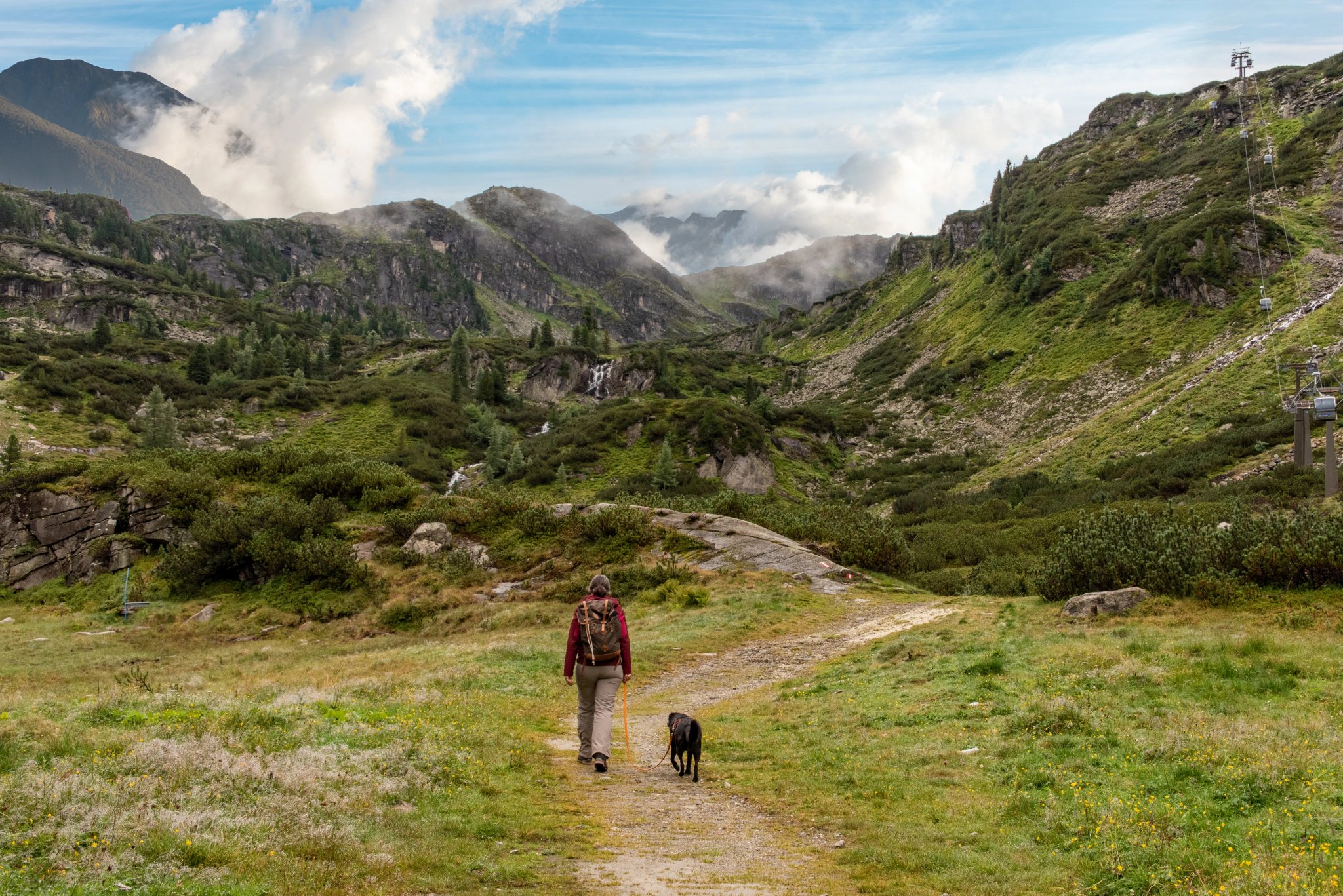 Femme randonnant avec son chien dans le parc national des Hohe Tauern