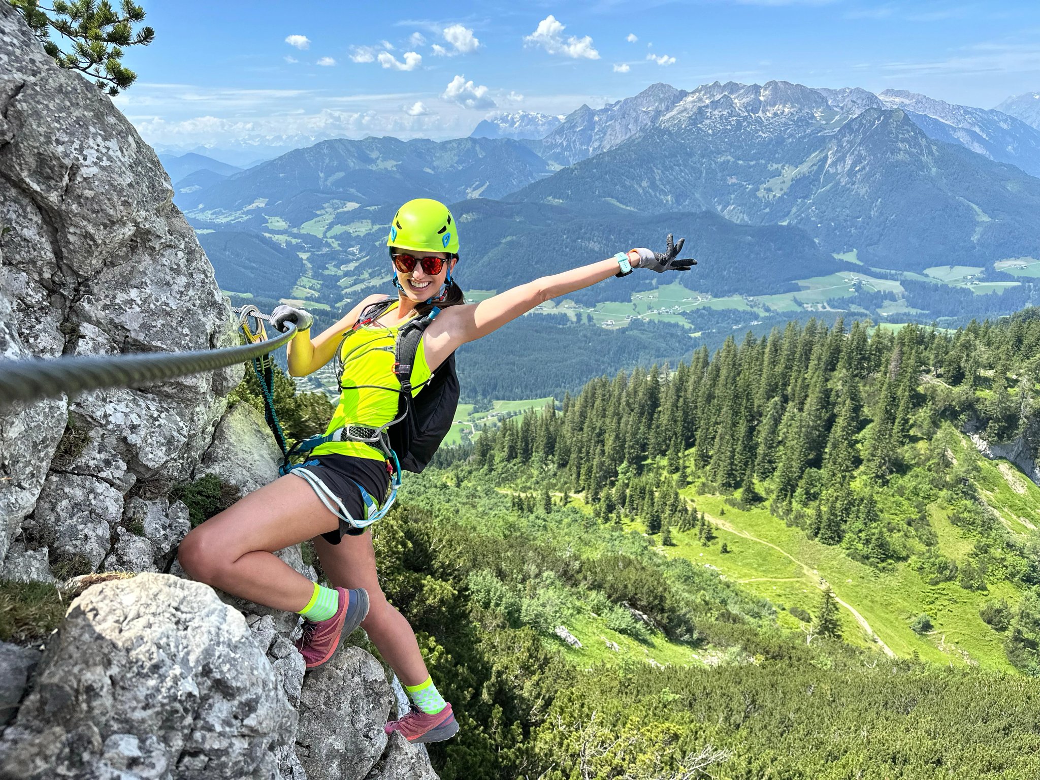Femme grimpeuse sur une via ferrata - escaladant une roche dans les Alpes autrichiennes