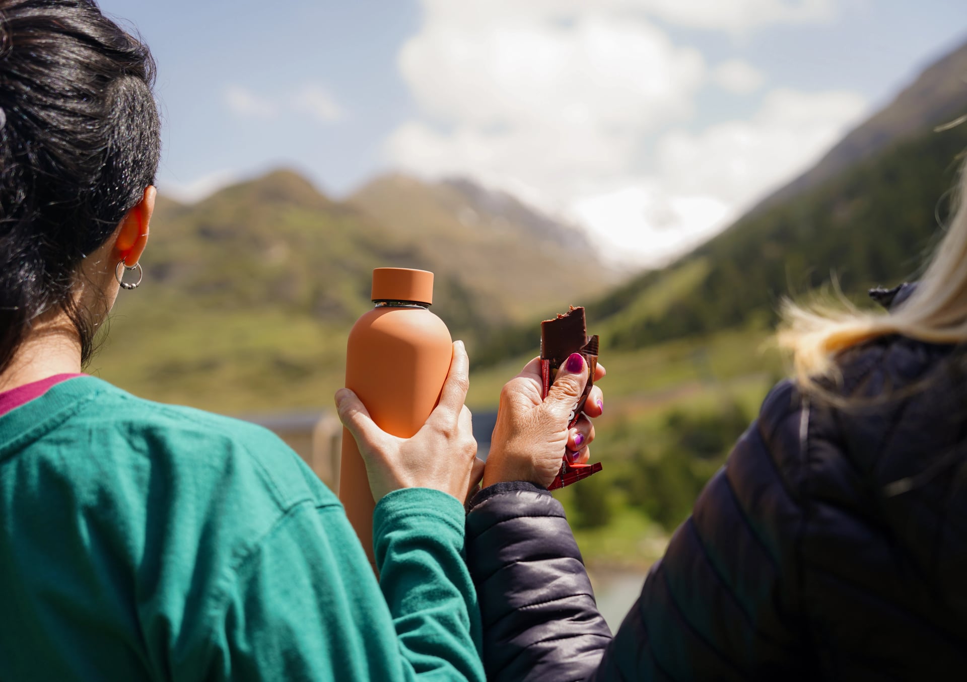 trekking con uno snack e acqua con paesaggio montano. pausa per mangiare e bere acqua durante l'escursione