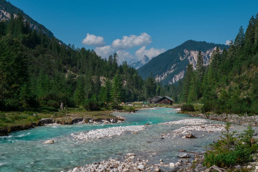 Turquoise river Isar flowing through the Karwendel mountains during sunny blue sky day in summer, Tyrol Austria.