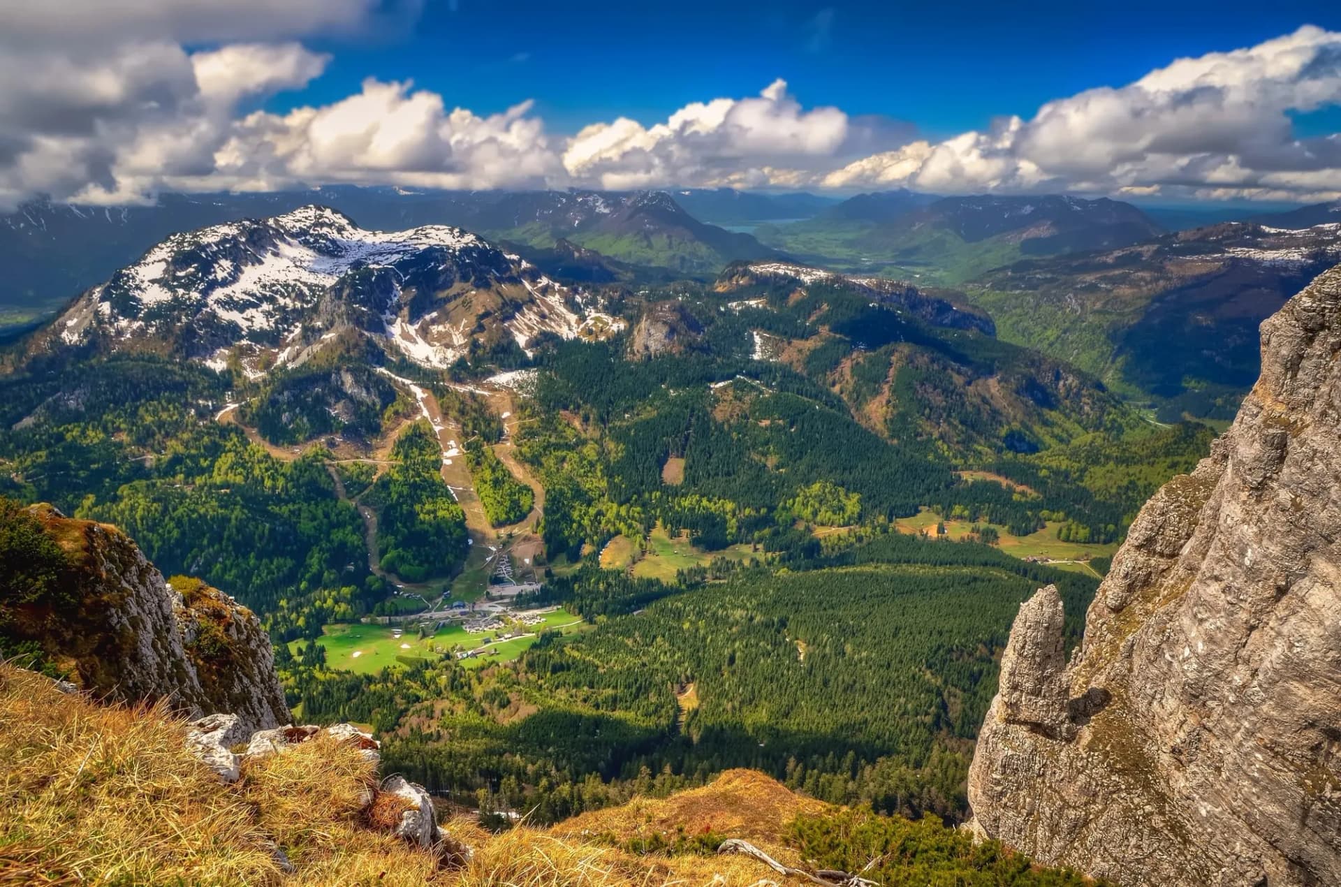 Mountain landscape in Austria. View from Loser peak over summits, rocky cliff and village in green valley, Dead Mountains (Totes Gebirge), group of mountains in Austrian Alps.