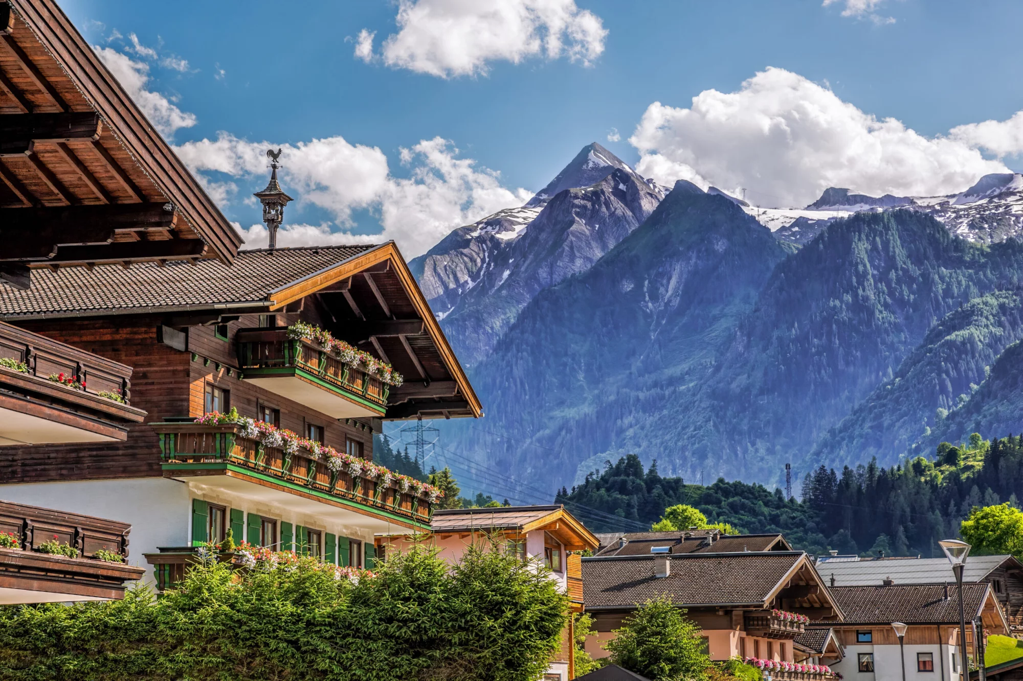 Pueblo de Kaprun con pensión típica frente al glaciar Kitzsteinhorn en la región de Salcburgo, Alpes austríacos